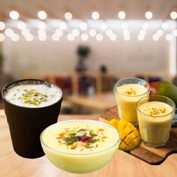 Indian mango lassi drinks and a bowl of mango dessert with nuts and saffron.