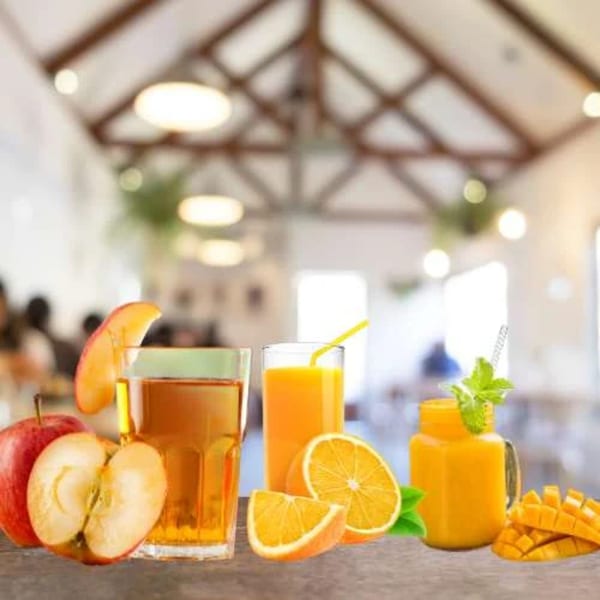 Fresh apple juice, orange juice, and mango juice with fruit slices on a wooden table.